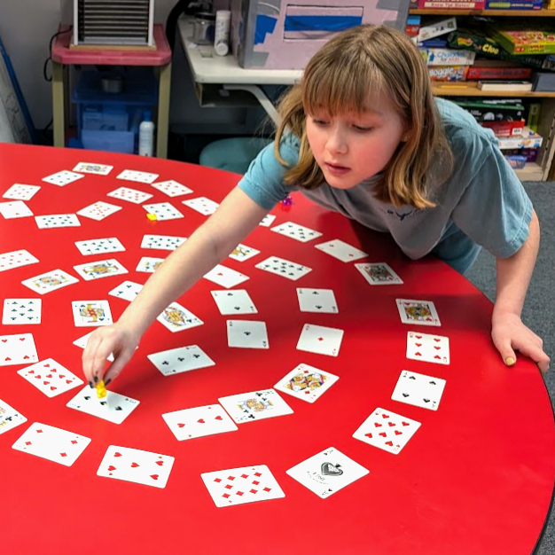 Student set up a spiral designed board game. 